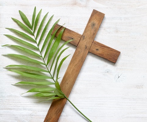 Wooden cross with a palm leaf